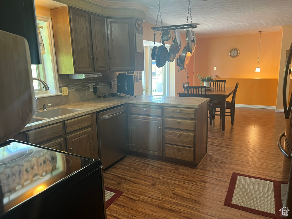 Kitchen with dishwasher, range, dark hardwood / wood-style flooring, and decorative light fixtures