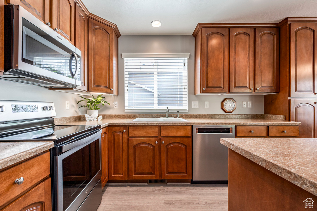 Kitchen featuring sink, light hardwood / wood-style flooring, and appliances with stainless steel finishes