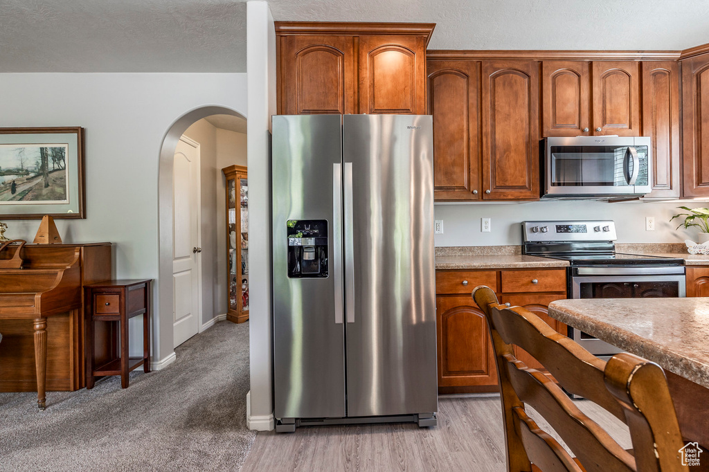 Kitchen featuring stainless steel appliances and light carpet