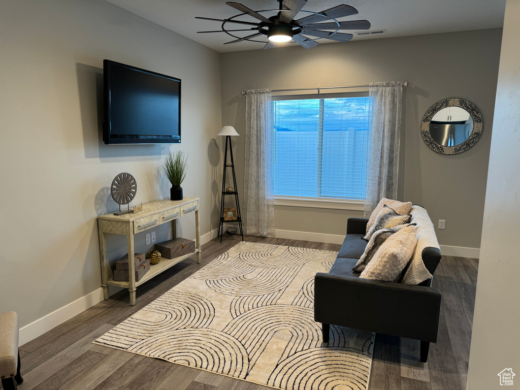 Living room with dark hardwood / wood-style floors and ceiling fan