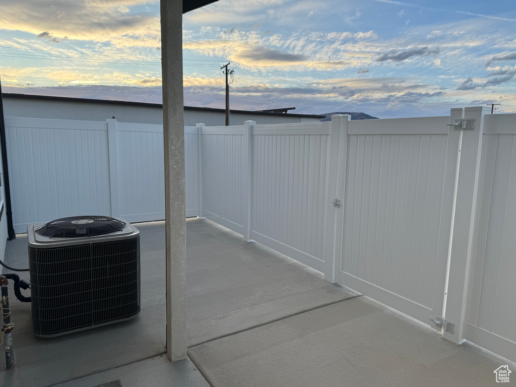 Patio terrace at dusk featuring central AC unit