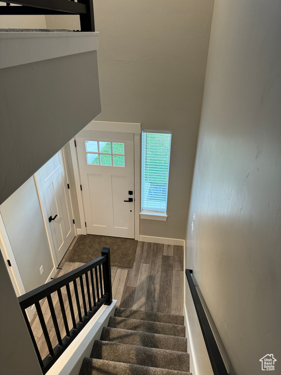 Stairway featuring a high ceiling and wood-type flooring