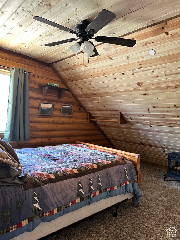 Unfurnished bedroom featuring ceiling fan, carpet flooring, log walls, lofted ceiling, and wooden ceiling