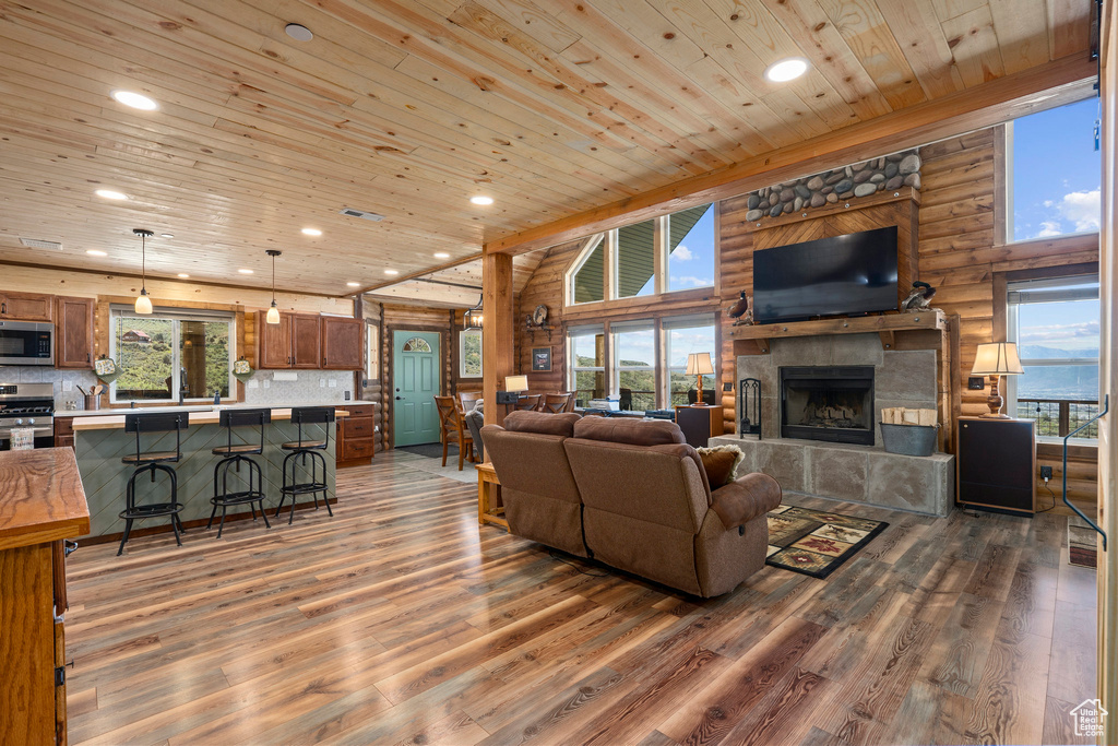 Living room featuring a healthy amount of sunlight, log walls, and hardwood / wood-style flooring