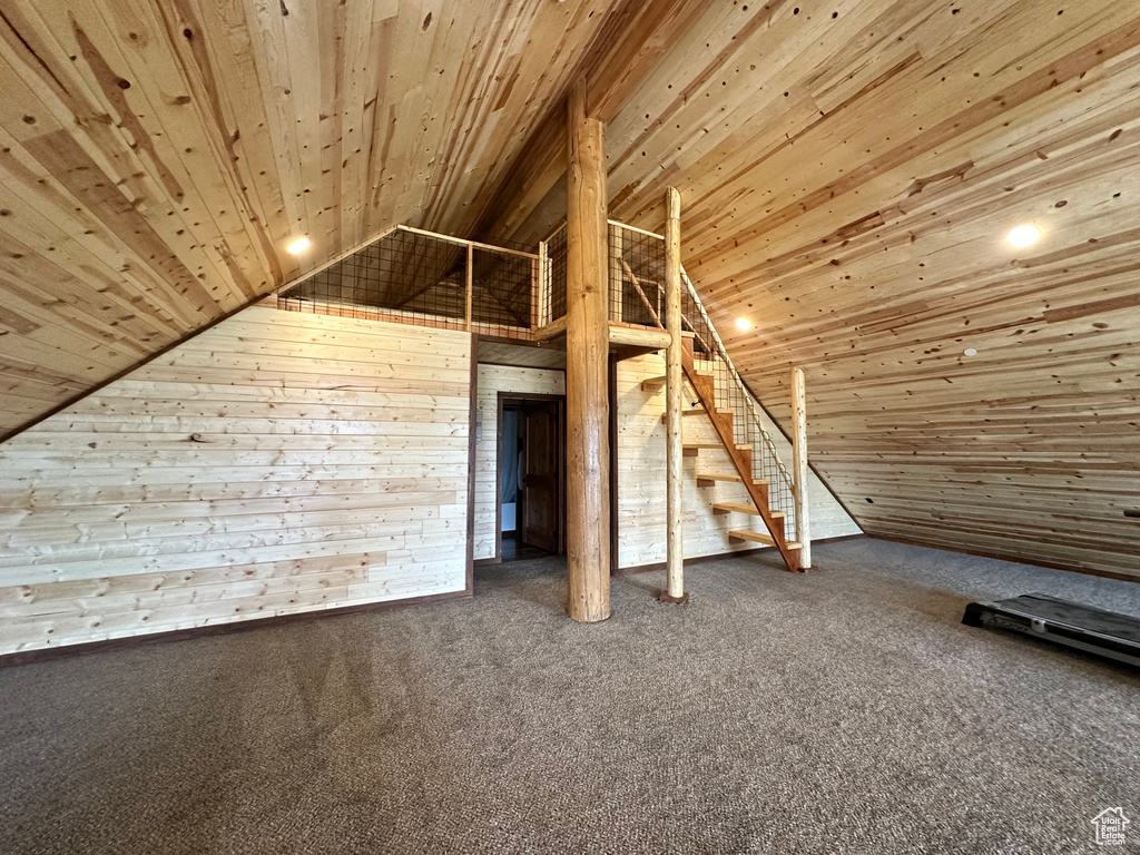 Additional living space featuring carpet flooring, wood walls, and wood ceiling