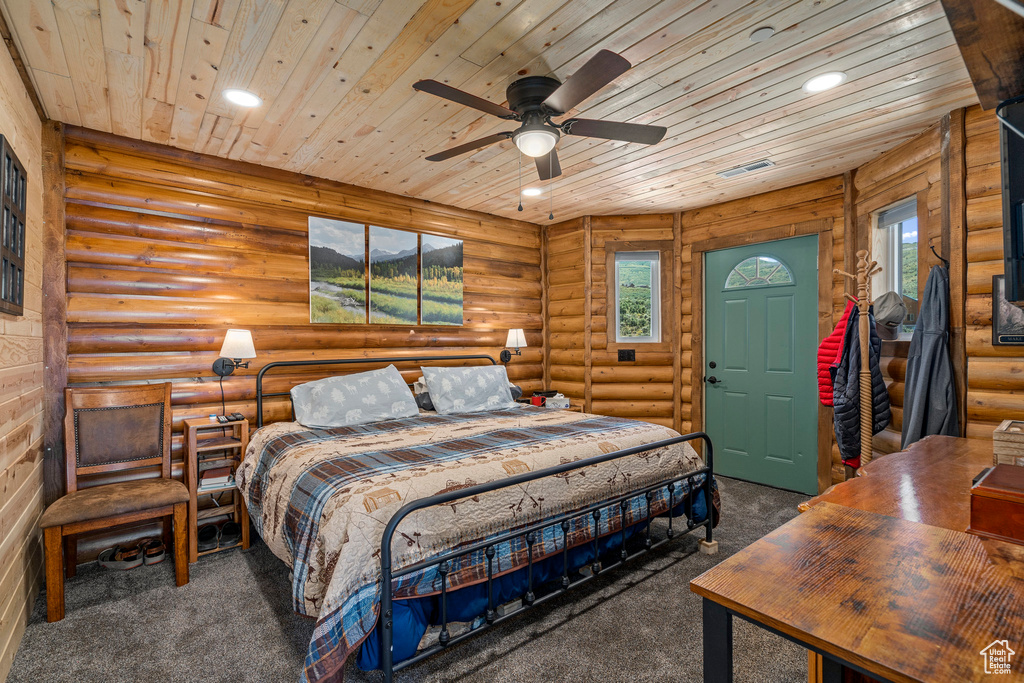 Bedroom featuring wooden ceiling, log walls, and carpet floors