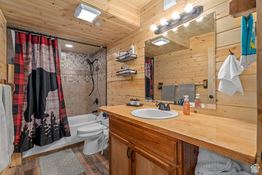 Full bathroom featuring vanity, shower / bath combination with curtain, wooden walls, hardwood / wood-style flooring, and wooden ceiling