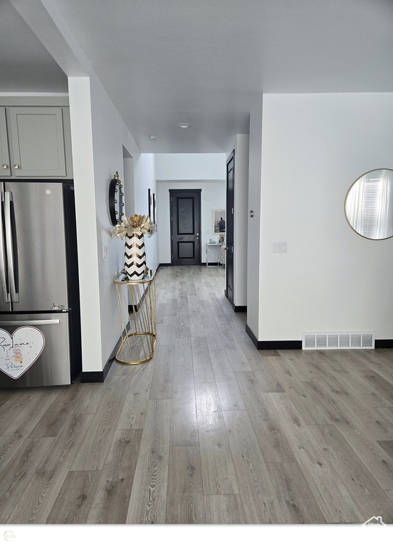 Interior space featuring hardwood / wood-style flooring, stainless steel refrigerator, and gray cabinets