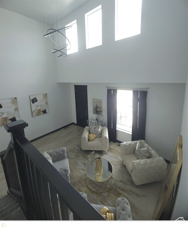 Living room with a high ceiling and wood-type flooring