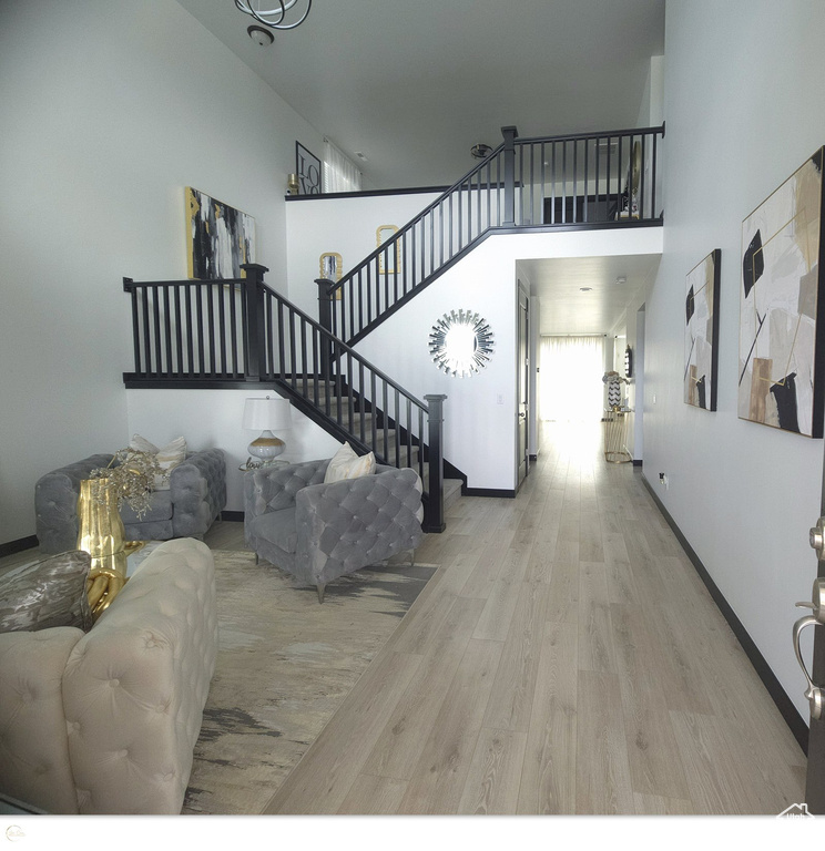 Living room featuring a high ceiling and light wood-type flooring