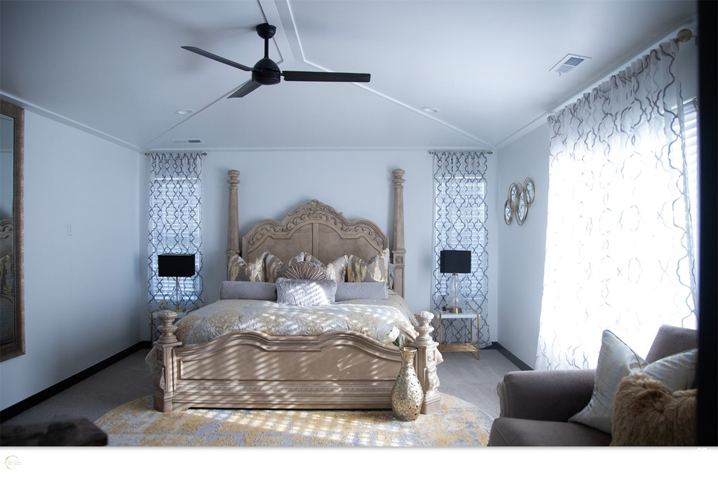 Carpeted bedroom with vaulted ceiling and ceiling fan