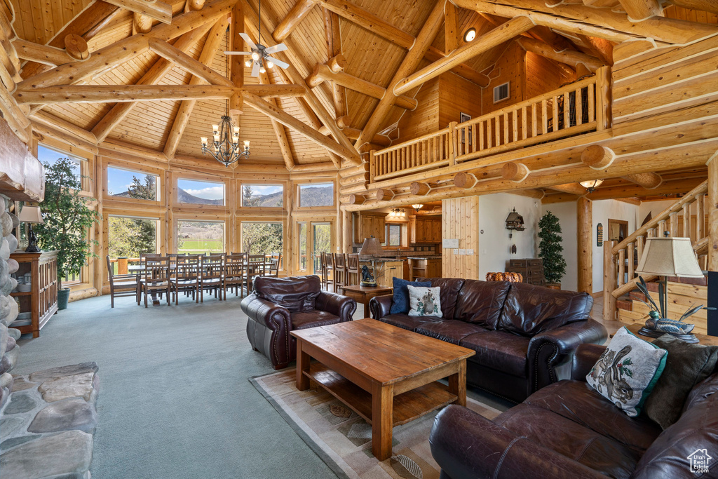 Carpeted living room featuring high vaulted ceiling, wooden ceiling, a chandelier, and beam ceiling