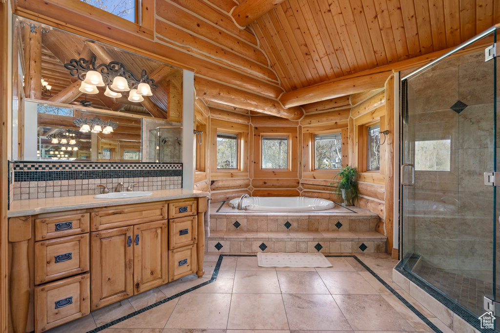 Bathroom with tile floors, rustic walls, plus walk in shower, and vanity