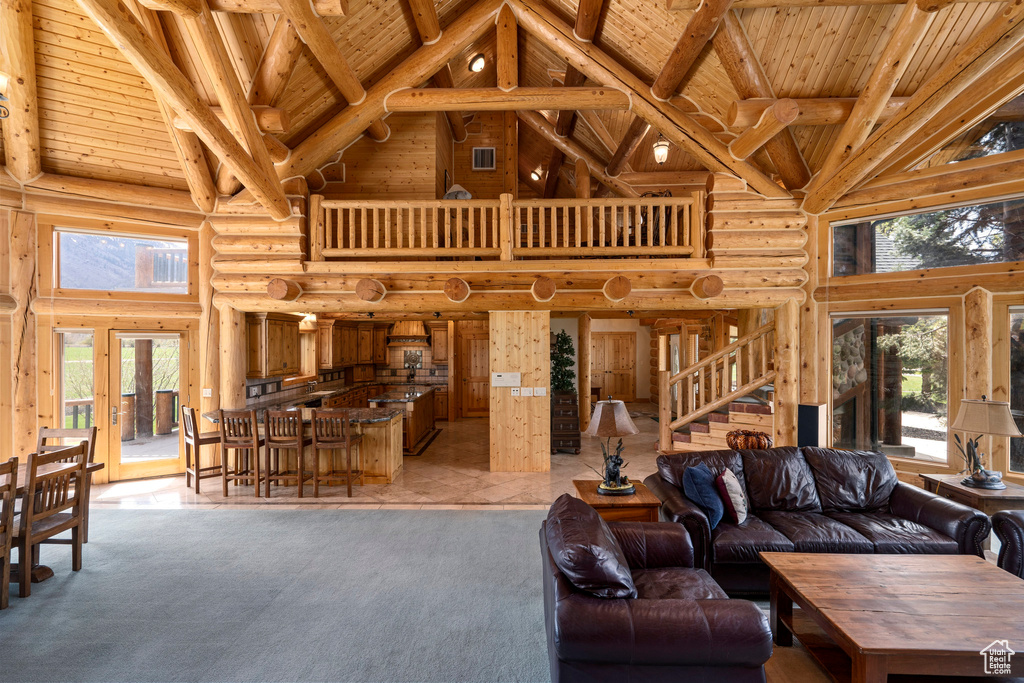 Tiled living room featuring beamed ceiling, high vaulted ceiling, wooden ceiling, and log walls