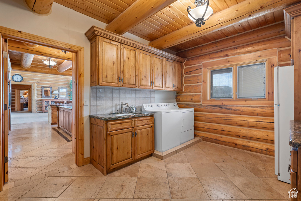 Laundry area with cabinets, rustic walls, light tile floors, and wood ceiling