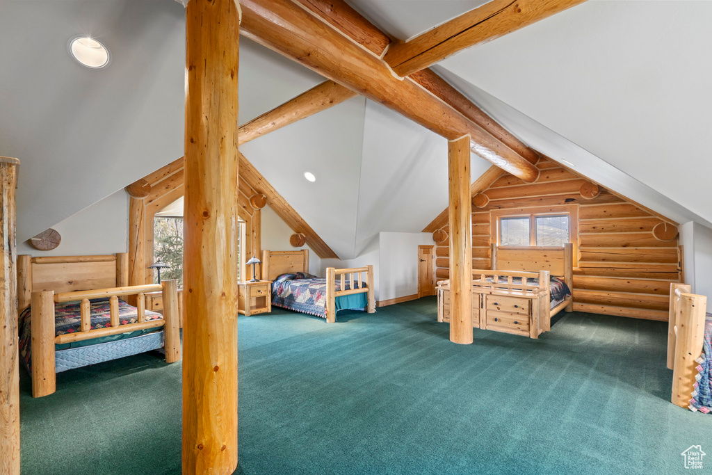 Carpeted bedroom featuring lofted ceiling with beams and rustic walls