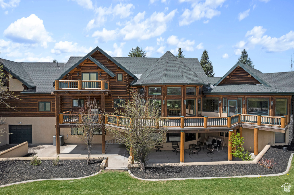 Back of property with a patio area, a wooden deck, and a yard