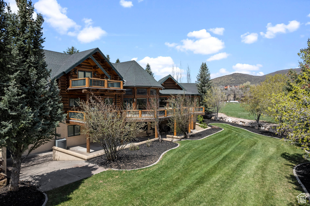 View of yard with a deck with mountain view, central air condition unit, a balcony, and a patio