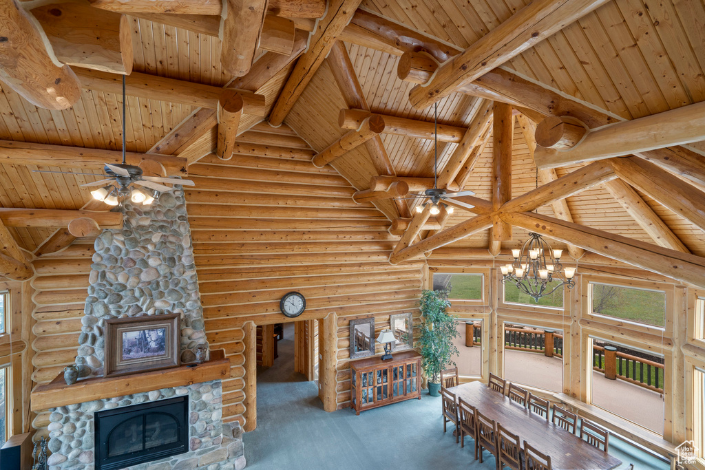 Interior space with a stone fireplace, wooden ceiling, beam ceiling, and rustic walls
