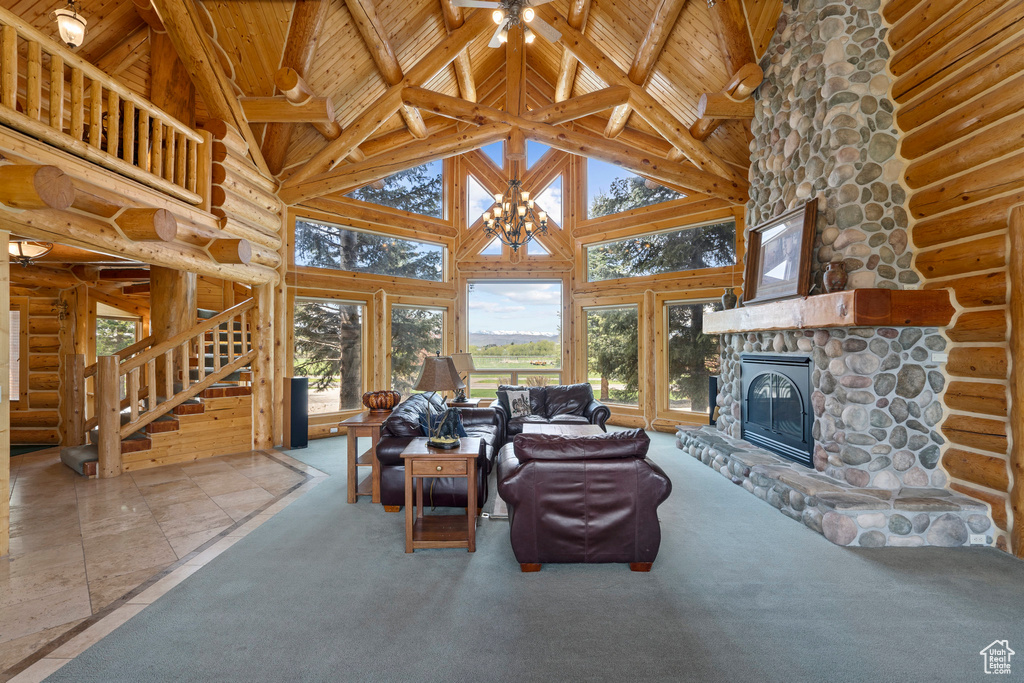 Carpeted living room with high vaulted ceiling, rustic walls, and wood ceiling