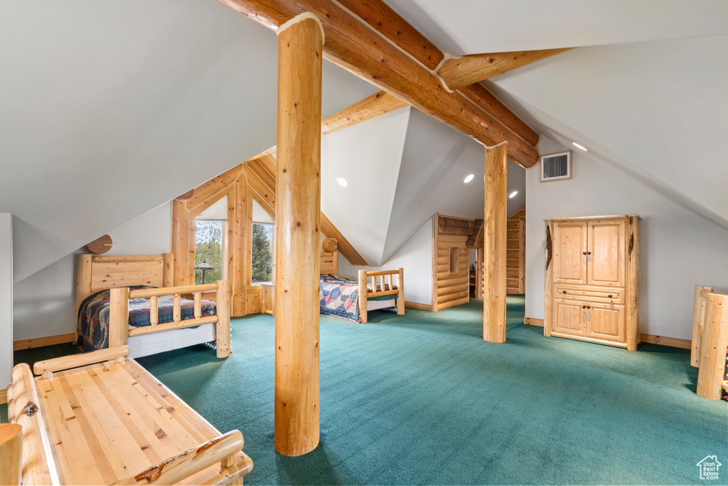 Carpeted bedroom featuring vaulted ceiling with beams