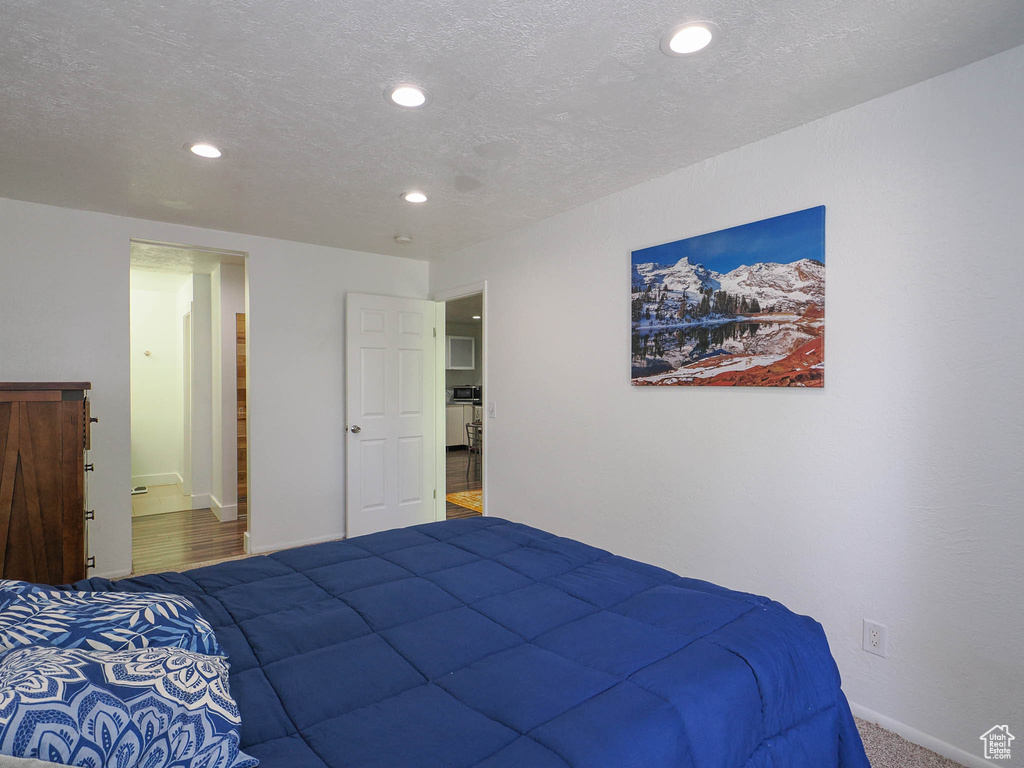 Bedroom with hardwood / wood-style floors and a textured ceiling