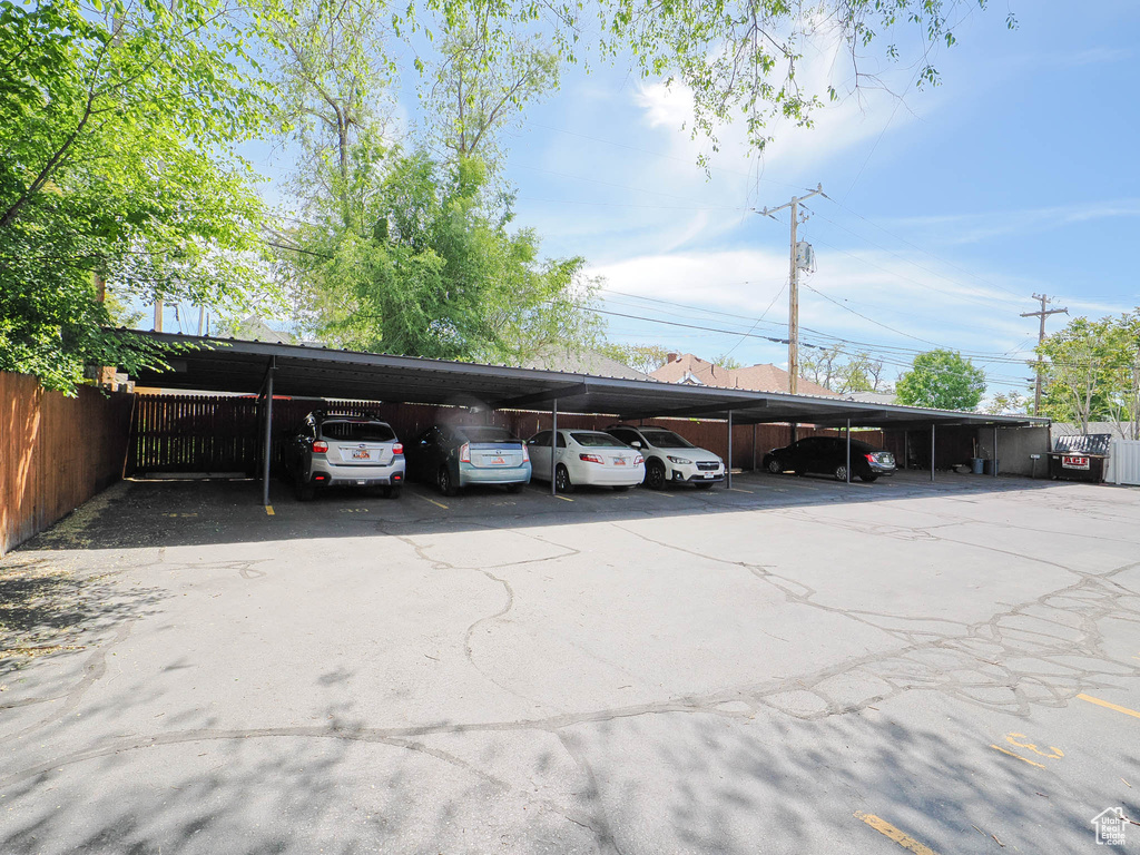 View of parking / parking lot featuring a carport