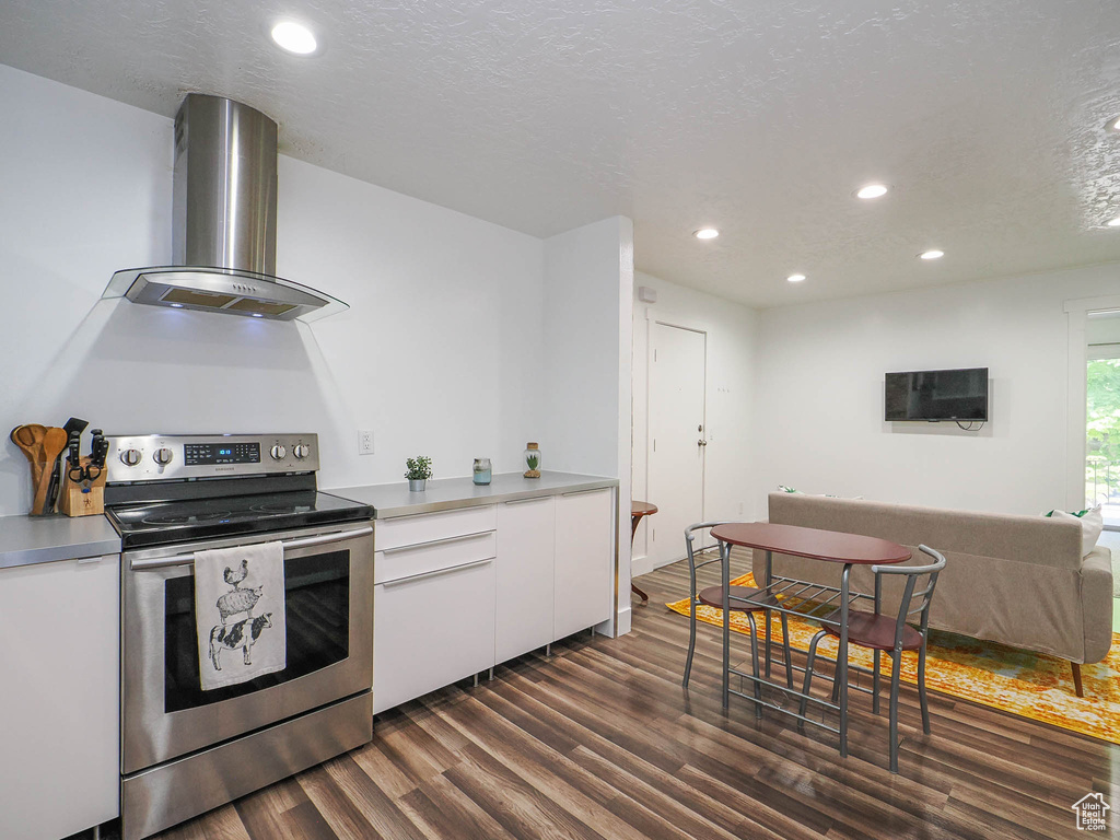 Kitchen featuring stainless steel electric range, dark hardwood / wood-style floors, white cabinetry, ventilation hood, and a textured ceiling