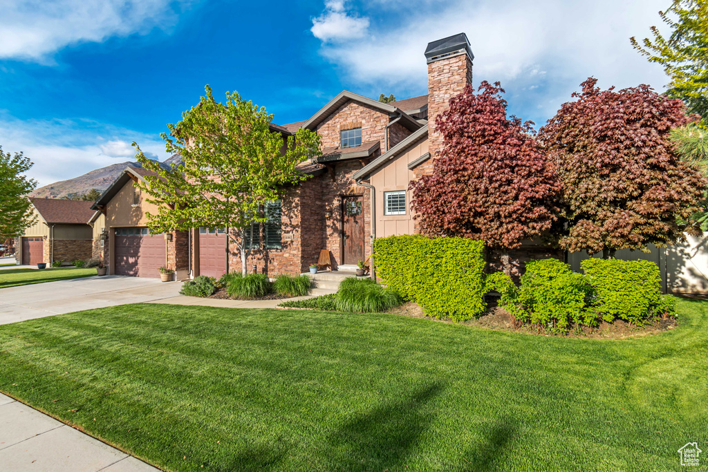 View of front of property with a front lawn and a garage