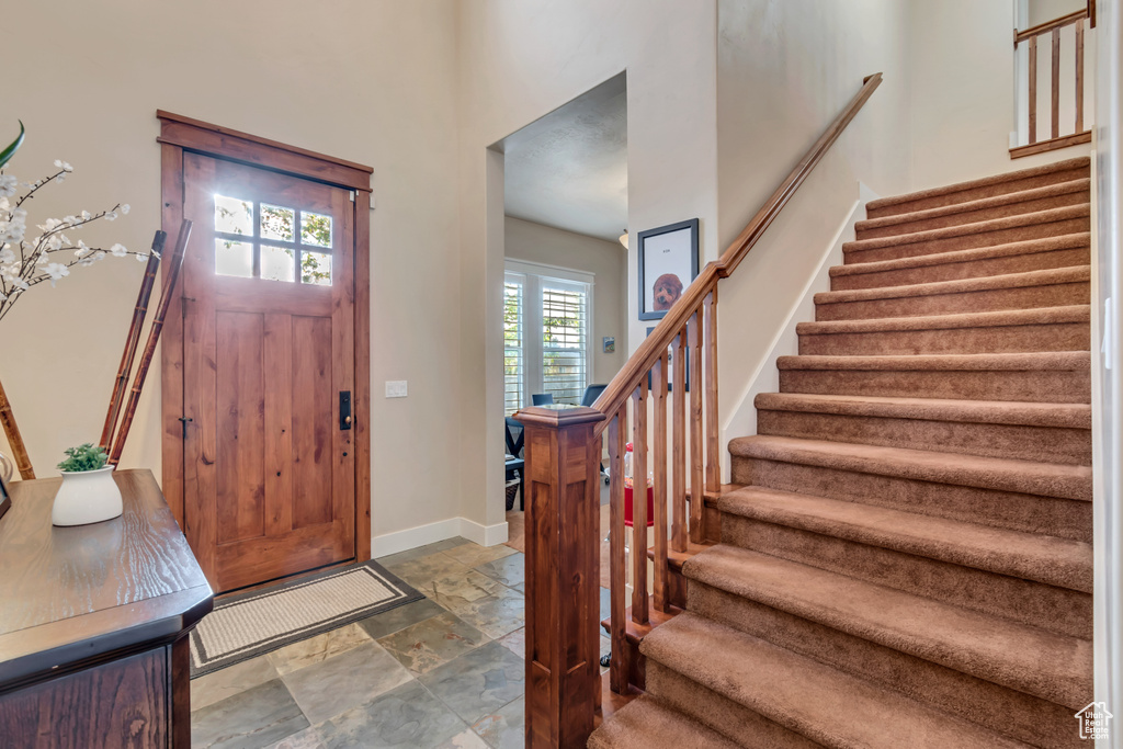 Entrance foyer featuring tile floors and a towering ceiling