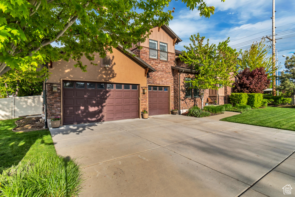 View of front facade with a garage and a front lawn