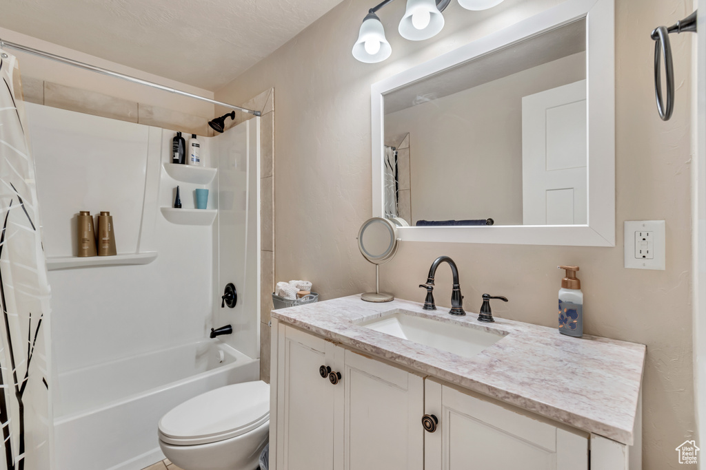 Full bathroom featuring vanity with extensive cabinet space, toilet, and shower / tub combo with curtain