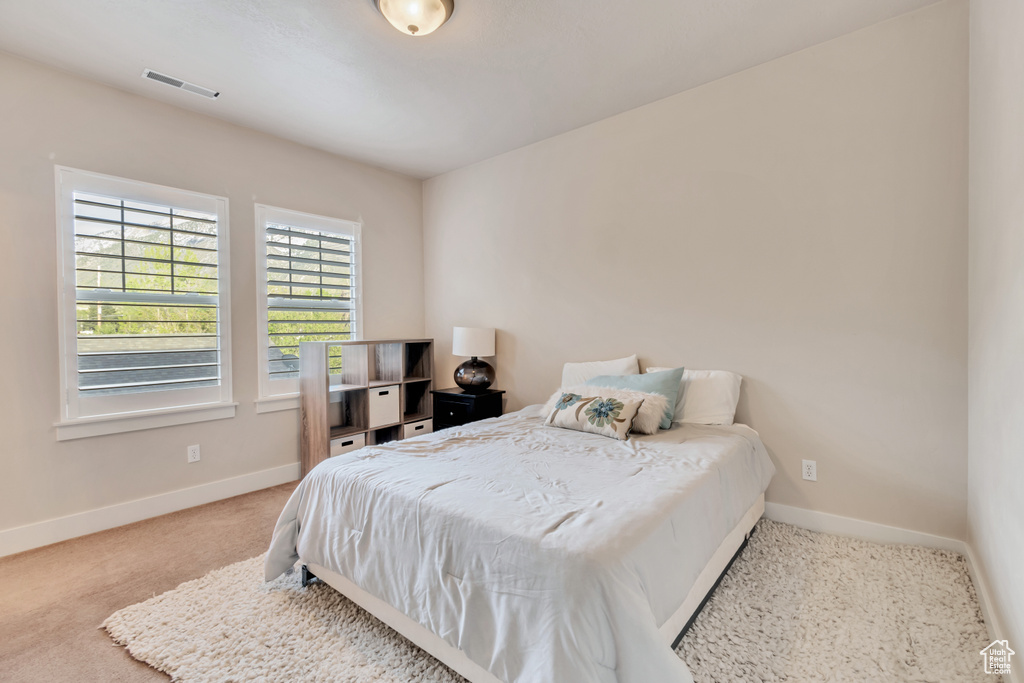 Bedroom featuring light carpet