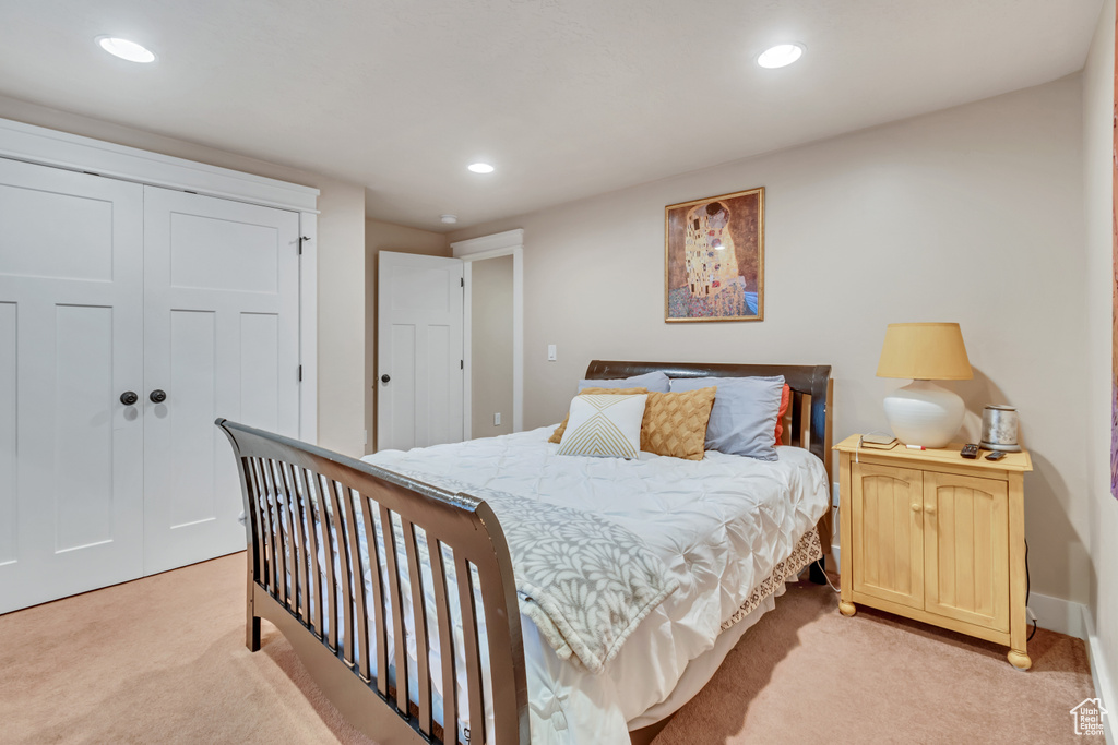 Bedroom with light carpet and a closet