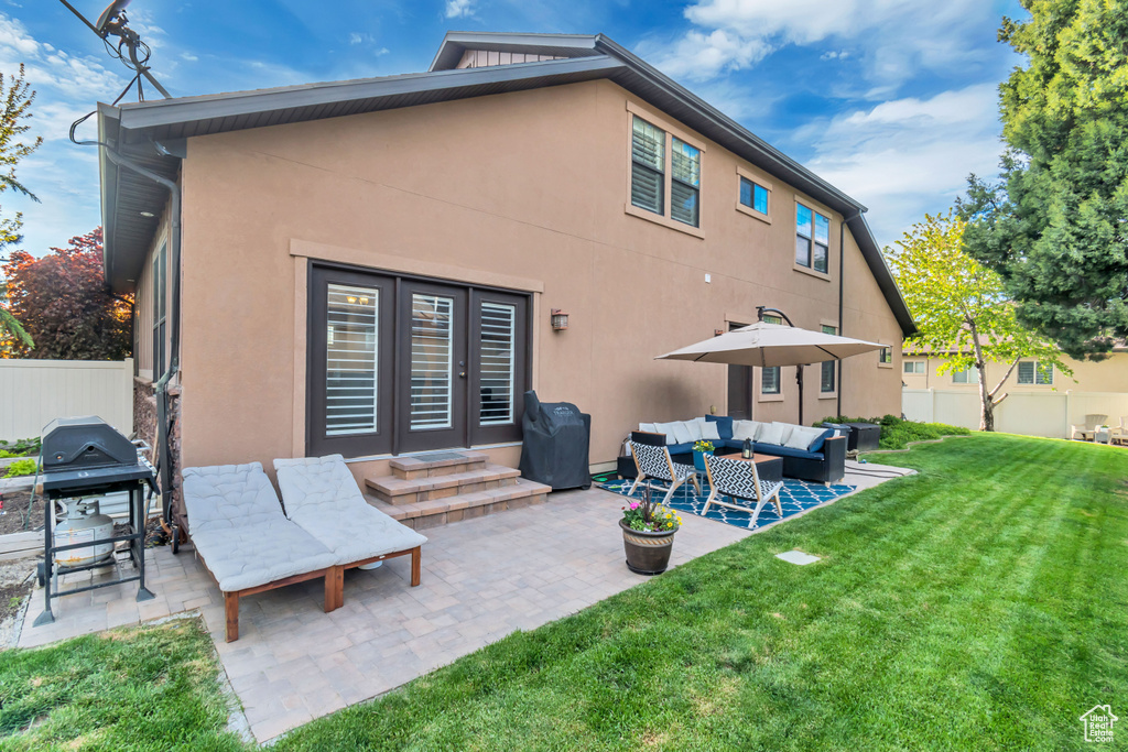 Back of house featuring outdoor lounge area, a patio, french doors, and a yard