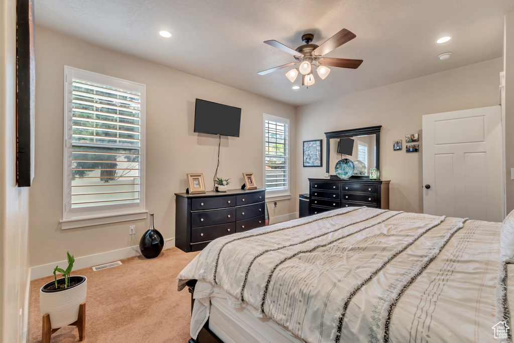 Carpeted bedroom featuring ceiling fan