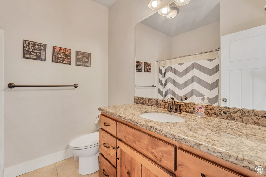 Bathroom featuring tile flooring, oversized vanity, and toilet