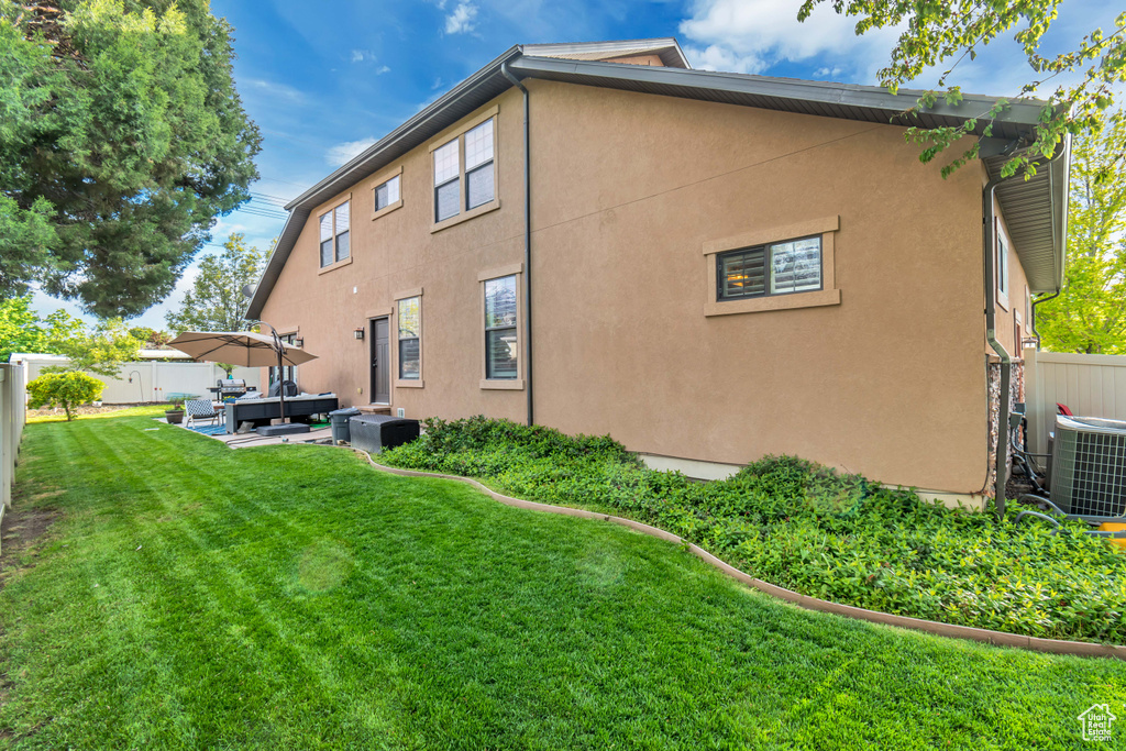 Back of property featuring outdoor lounge area, a lawn, a patio area, and central air condition unit