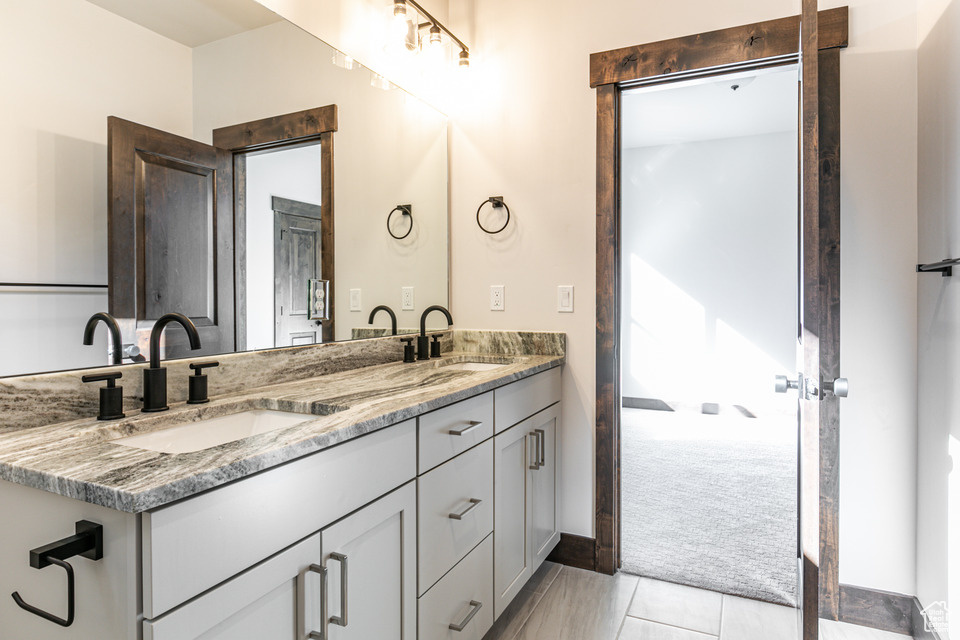 Bathroom with tile flooring, oversized vanity, and double sink