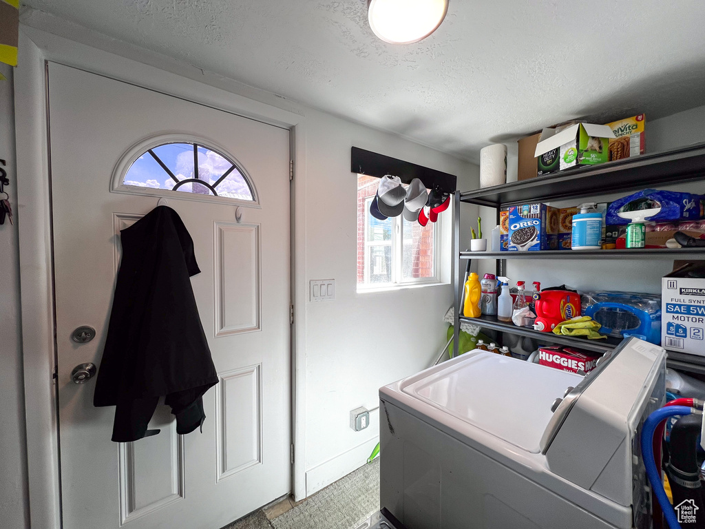 Laundry area featuring washer and clothes dryer, a textured ceiling, and a wealth of natural light