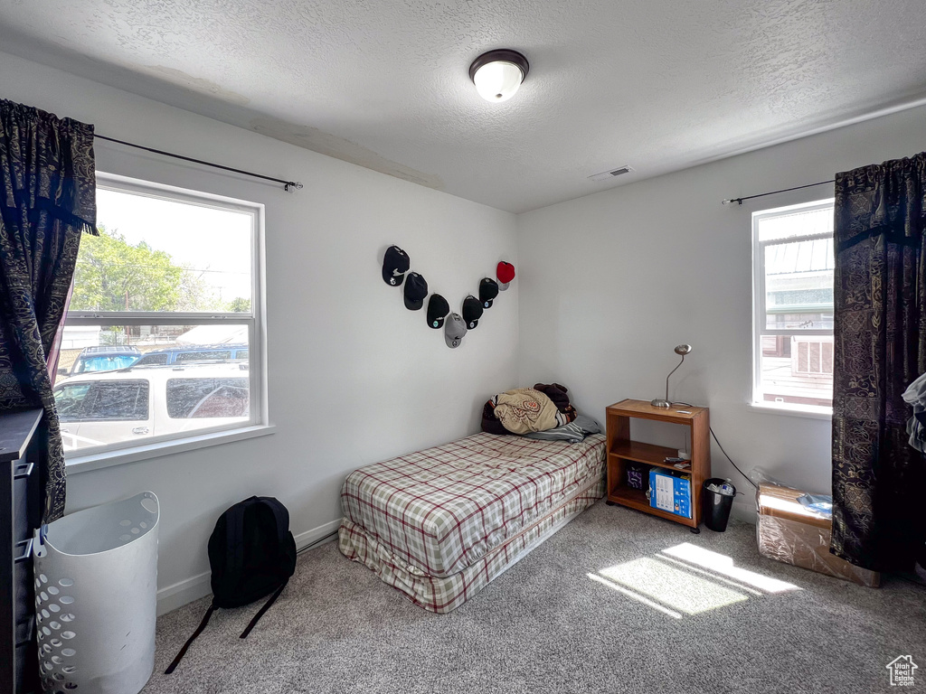 Bedroom with light carpet and a textured ceiling