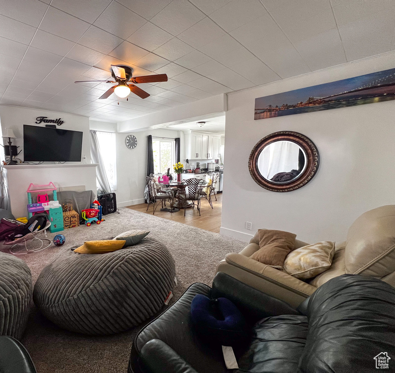 Living room with ceiling fan and hardwood / wood-style flooring