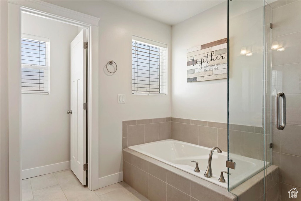 Bathroom with tile flooring, plenty of natural light, and tiled tub