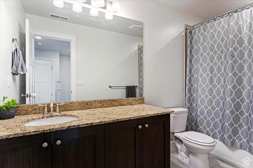 Full bathroom with shower / bath combination with curtain, vanity, toilet, and tile floors