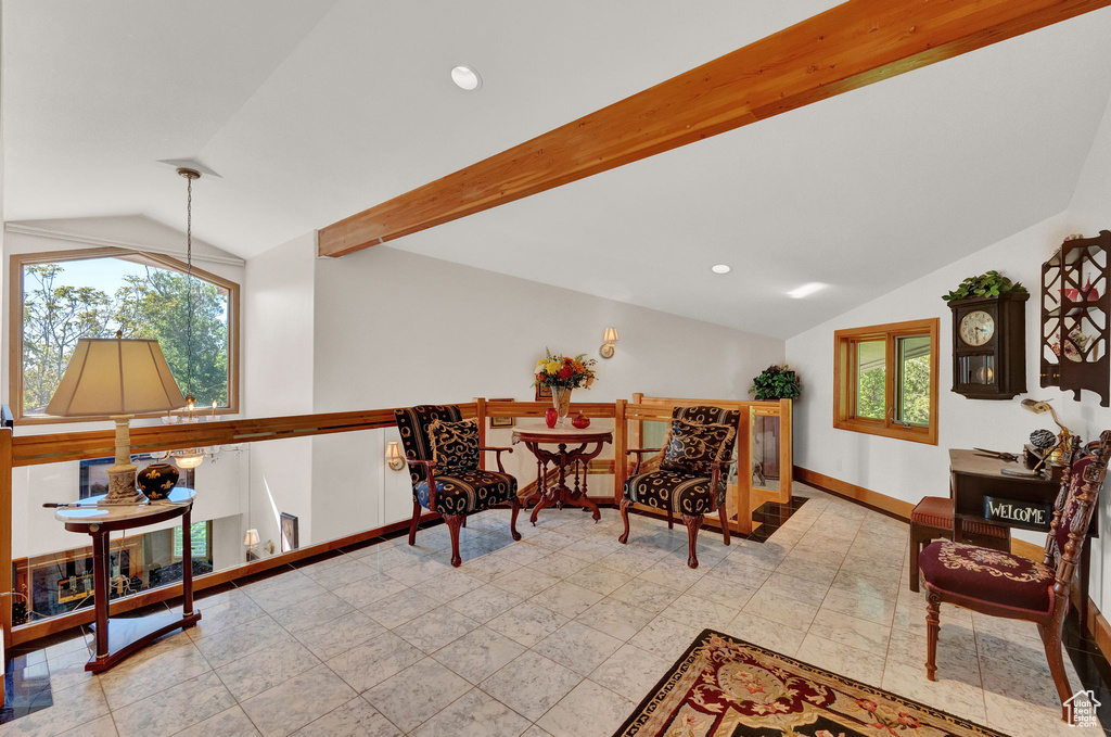 Interior space with lofted ceiling with beams and light tile floors