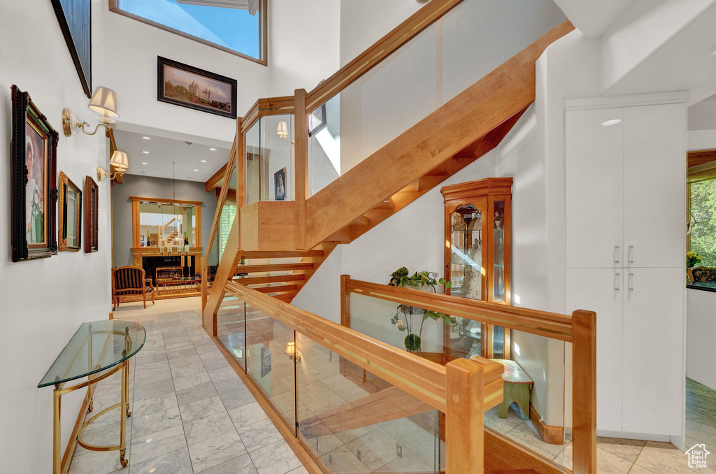 Stairway featuring a high ceiling and light tile floors