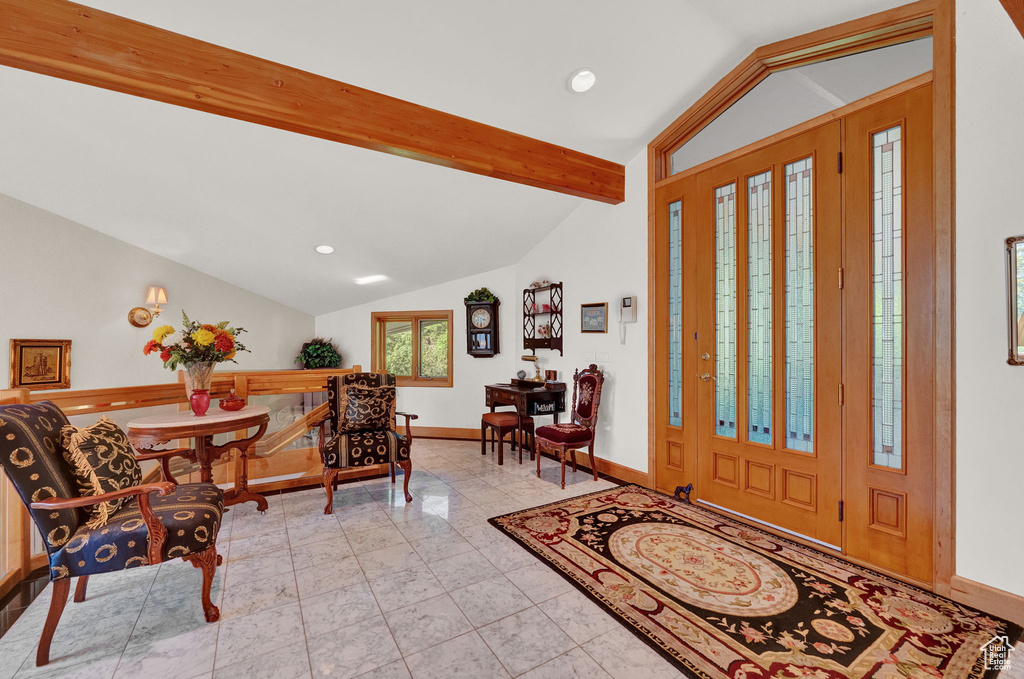 Tiled foyer entrance with vaulted ceiling with beams