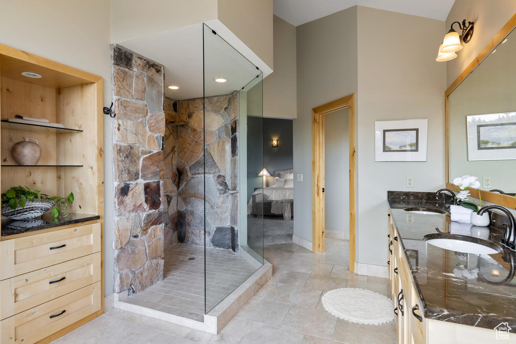 Bathroom with walk in shower, dual bowl vanity, and tile floors