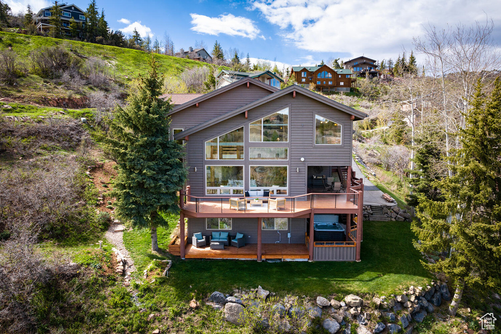 Rear view of property with a lawn and a wooden deck