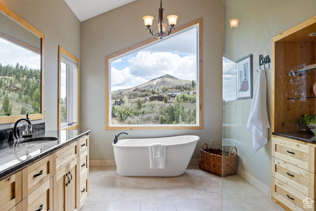 Bathroom with a healthy amount of sunlight, tile flooring, a chandelier, and oversized vanity